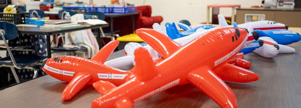 Red and blue airplane balloons sitting on the table.