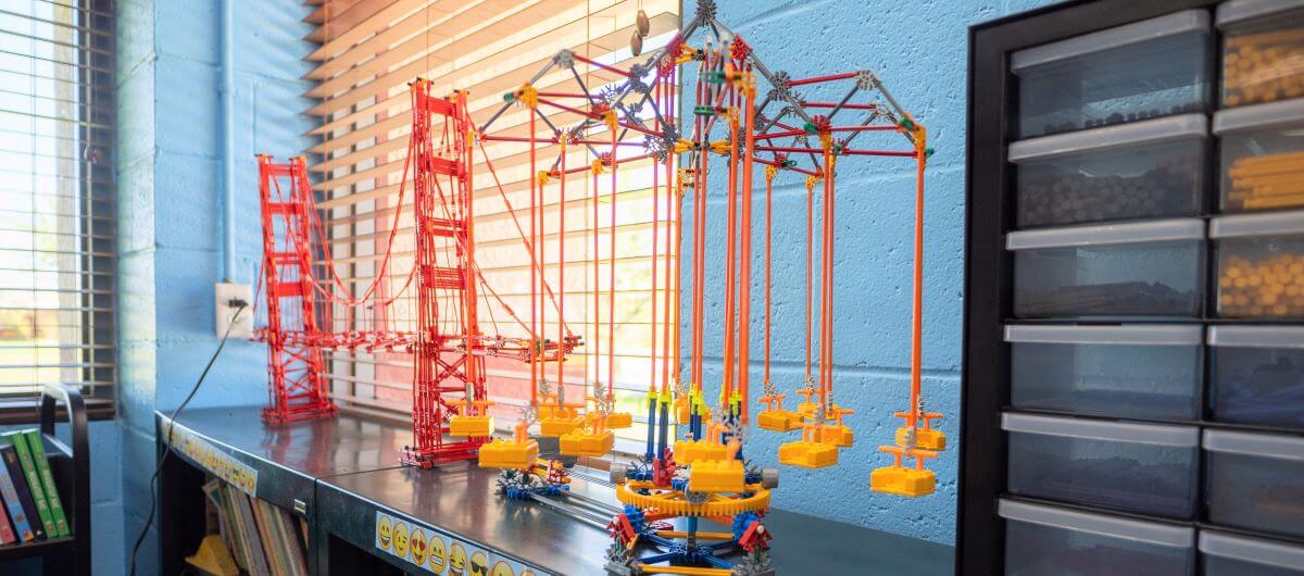 Toy legos of a red bridge sitting on a shelf.