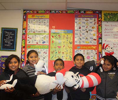 students holding a large stuffed cat in the hat from dr seuss