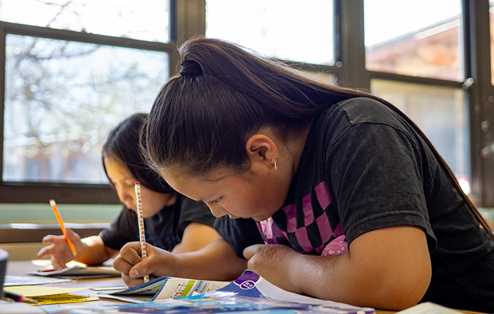 Two female students doing a test during class. 