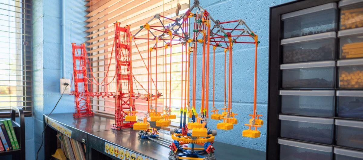 Toy legos of a red bridge sitting on a shelf.