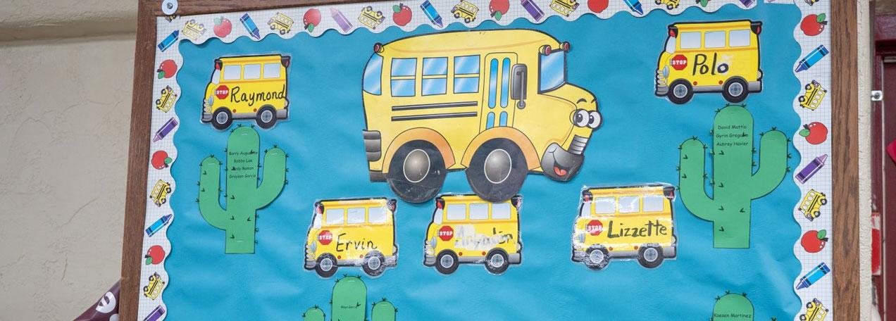 Student artwork of yellow school buses on a wall. 