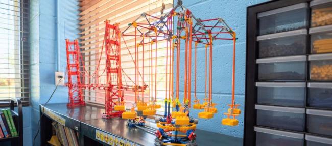 Toy legos of a red bridge sitting on a shelf.