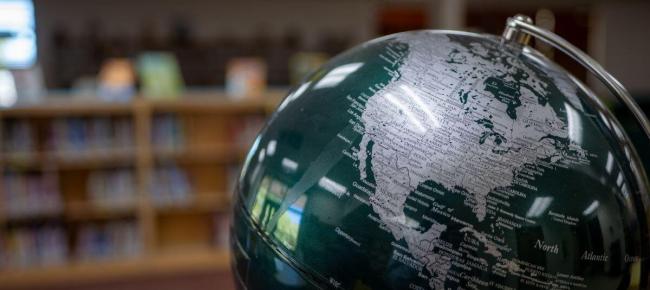 Classroom globe with blurred bookshelf background