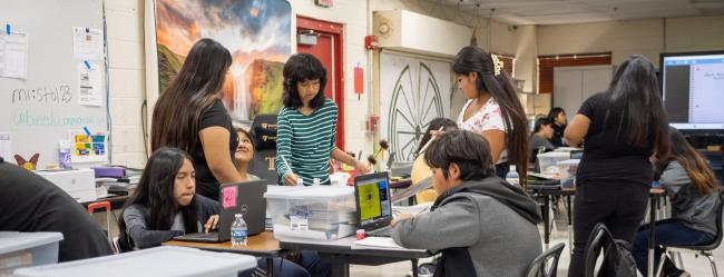 Busy classroom with students working on various projects.