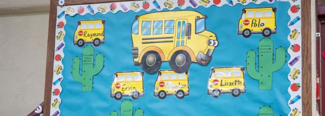 Student artwork of yellow school buses on a wall. 